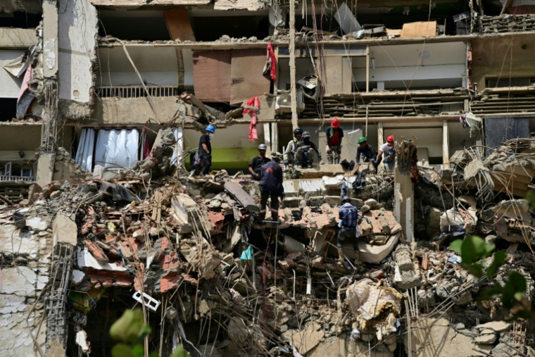 Des secouristes recherchent des victimes sur le site d'un immeuble effondré à Catia La Mar, dans l'État de La Guaira, le 6 juillet 2026 au Venezuela ( AFP / MARTIN BERNETTI )