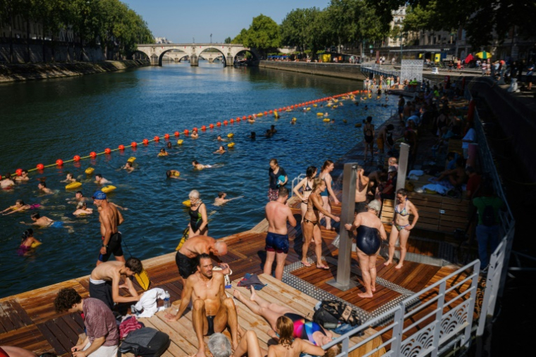 Des baigneurs dans la Seine au bras Marie à Paris le 12 août 2025 ( AFP / Dimitar DILKOFF )