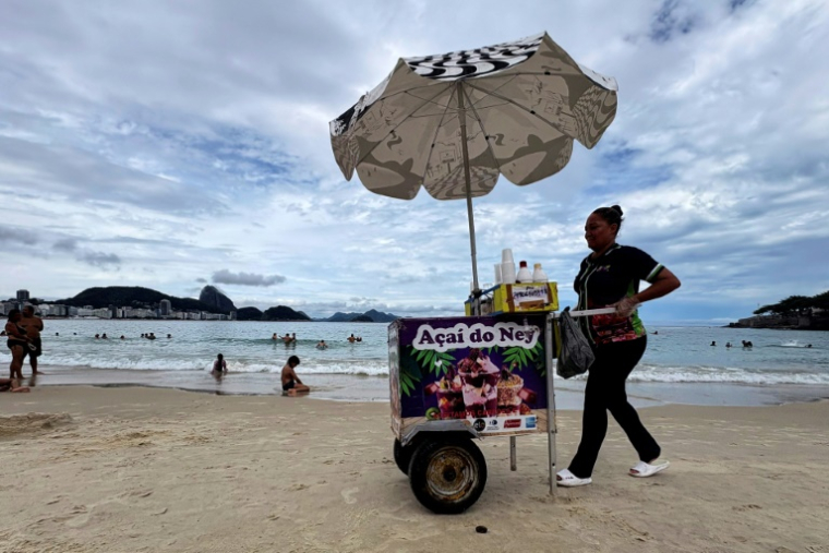 Une vendeuse de jus d'açaï, sur la plage de Copacabana, à Rio de Janeiro, le 24 janvier 2026 ( AFP / Pablo PORCIUNCULA )