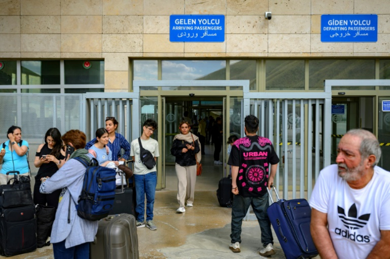Des Iraniens arrivent en Turquie par le poste frontière de Razi-Kapiköy, dans le nord-est de la Turquie, le 18 juin 2025 ( AFP / Yasin AKGUL )