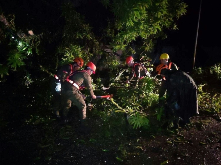 Photo de l'armée philippine montrant des soldats déblayant des branches abattues par la tempête tropicale Bualoi le 25 septembre 2025 à San Policarpio ( PHILIPPINE ARMY / Handout )