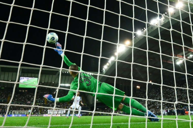 Lucas Chevalier arrête le tir au but du défenseur des Spurs Micky van de Ven et permet au PSG de remporter la Supercoupe contre Tottenham le 13 août 2025 à Udine en Italie ( AFP / Marco BERTORELLO )