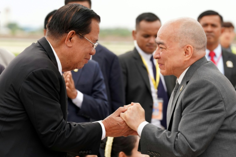 Photo fournie et diffusée par l’Agence Kampuchea Press (AKP) le 3 juillet 2026 montrant le roi du Cambodge Norodom Sihamoni (à droite) salué par l'ancien dirigeant cambodgien Hun Sen (à gauche) à son arrivée à l’aéroport international près de Phnom Penh ( AFP / TANG CHHIN Sothy )