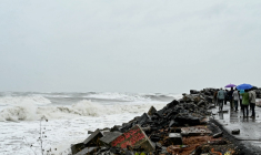 Des passants le long de la côte du golfe du Bengale, à Kakinada, en Inde, le 27 octobre 2026, avant le passage attendu du cyclone Arnab ( AFP / NOAH SEELAM )