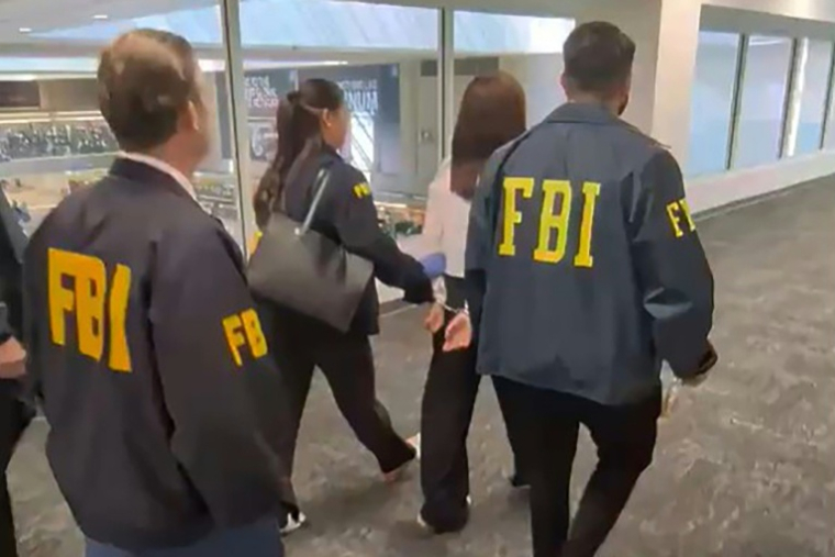 Capture d'image d'une vidéo diffusée sur le compte X du procureur fédéral adjoint américain Bill Essayli le 4 octobre 2026 montrant des agents du FBI avec Wanying Zhang après son arrestation à l'aéroport de Los Angeles, aux Etats-Unis ( X account of US Attorney Bill Essayli / Handout )
