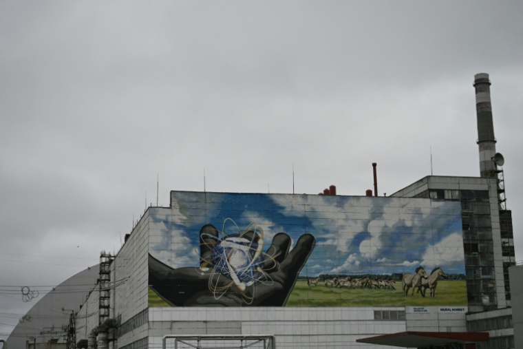 La centrale nucléaire de Tchernobyl et, en arrière plan, une partie du nouveau confinement de sécurité, un dôme métallique recouvrant le sarcophage du quatrième réacteur détruit lors de l'invasion russe de l'Ukraine, le 9 avril 2026 à Tchernobyl ( AFP / Genya SAVILOV )