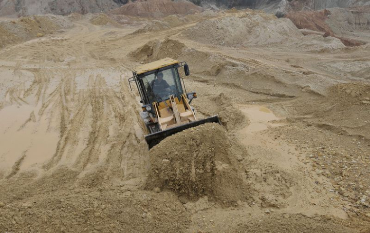 Un ouvrier opère un bulldozer sur un site d'extraction de terres rares dans le comté de Nancheng, province du Jiangxi