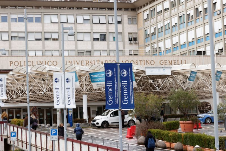 Des personnes marchent devant l'hôpital Gemelli où le pape François est hospitalisé à Rome