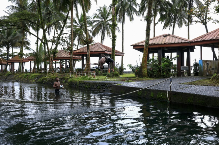 Un touriste dans la piscine de l'hôtel Seme Beach, à Limbé, le 4 octobre 2025 au Cameroun ( AFP / Daniel BELOUMOU OLOMO )