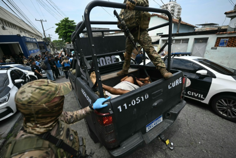 Des policiers transportent dans un véhicule des corps vers un hôpital lors d'une opération dans la favela de Vila Cruzeiro, dans le complexe de Penha, à Rio de Janeiro, le 28 octobre 2025 au Brésil ( AFP / Mauro PIMENTEL )