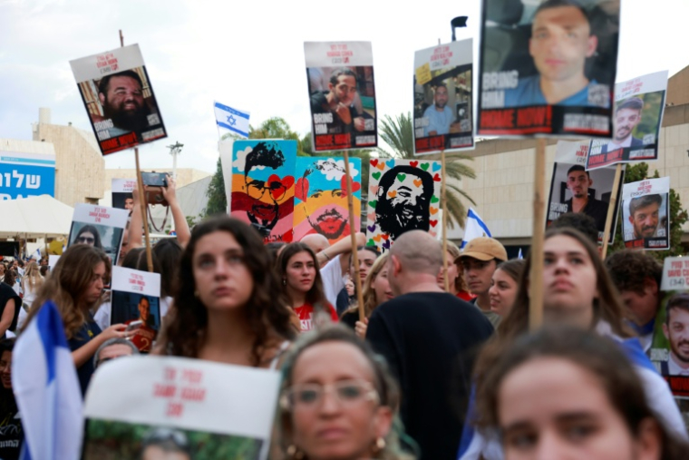 Des Israéliens attendent la libération des otages encore retenus à Gaza sur la place des Otages à Tel-Aviv, tôt le 13 octobre 2025 ( AFP / Menahem KAHANA )
