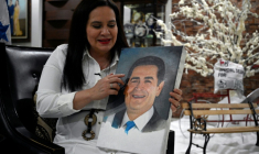 Ana García de Hernández, épouse de l'ancien président hondurien Juan Orlando Hernández, tient un portrait de son mari lors d'un entretien avec l'AFP à Tegucigalpa le 2 décembre 2025 ( AFP / Orlando SIERRA )