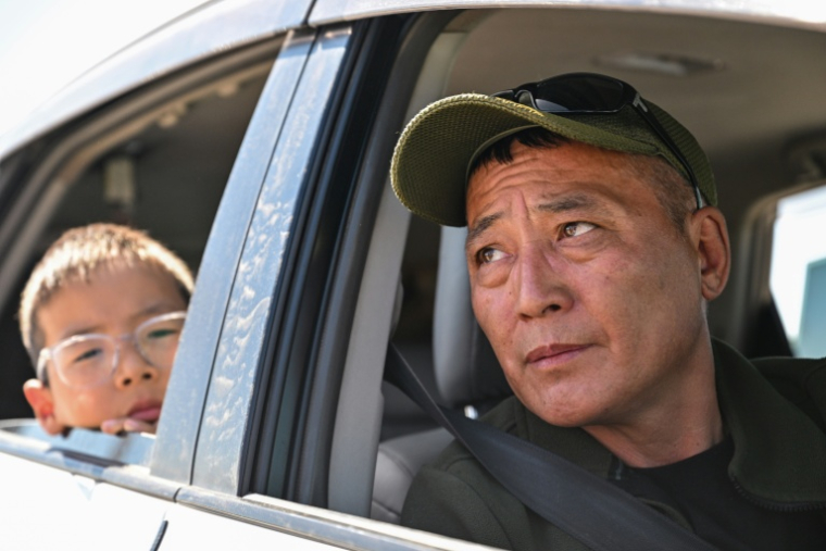 Nasanjargal, un ancien policier, s'entretient avec l'AFP alors qu'il attend de faire le plein de sa voiture dans une station-service de Bagakhangai, en Mongolie, le 25 août 2026 ( AFP / Hector RETAMAL )