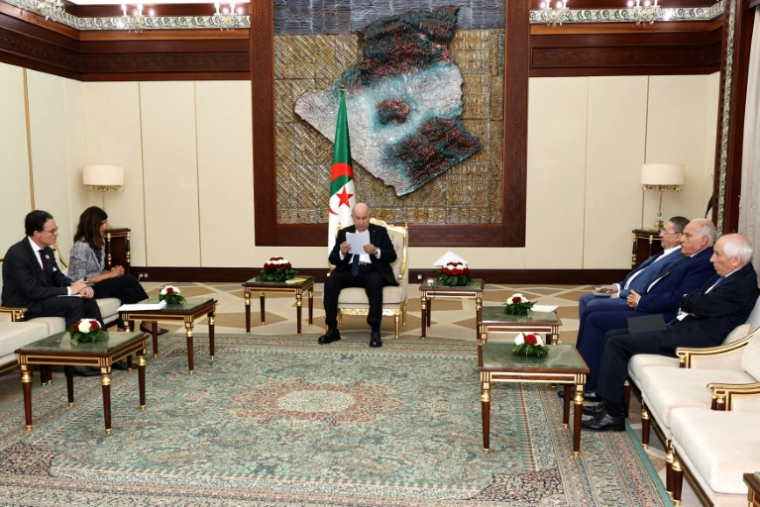 Photo prise sur la page Facebook de la présidence algérienne montrant l'ambassadeur de France en Algérie, Stéphane Romatet, et la ministre française déléguée aux Armées, Alice Rufo (G), assis près du président algérien, Abdelmadjid Tebboune (C), à Alger, le 9 mai 2026 ( ALGERIAN PRESIDENCY FACEBOOK PAGE / - )