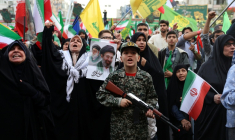 Un jeune Iranien en uniforme militaire brandit un fusil factice lors d'un rassemblement des partisans du pouvoir, le 29 avril 2029 à Téhéran ( AFP / - )