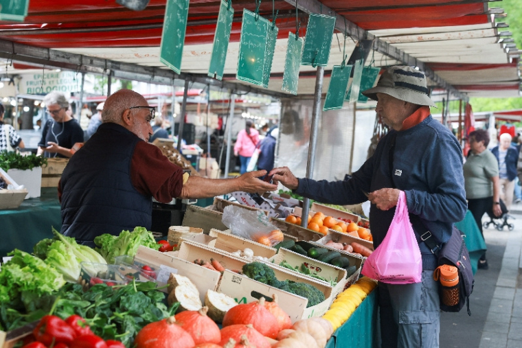 Des gens font leurs courses sur un marché de quartier à Paris