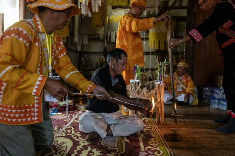 Photo fournie par Luke Duggleby, prise le 10 décembre 2025 et transmise à l'AFP le 25 février 2026, montrant le chef religieux Jaha Satae (c,d), procédant à une cérémonie de purification sur Jawa Jabo (chemise noire), dans le village de Mae Haeng, à Chiang Mai, en Thaïlande ( Courtesy of Luke Duggleby / Luke Duggleby )