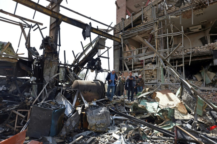 Des représentants des médias se rassemblent autour du bâtiment endommagé de l’université Shahid Beheshti après une frappe, à Téhéran, le 4 avril 2026 ( AFP / - )