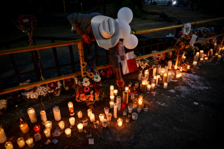 Un homme allume une bougie pendant que des amis et proches rendent hommage aux victimes devant la discothèque Jet Set à Saint-Domingue, en République dominicaine, le 11 avril 2025 ( AFP / MARTIN BERNETTI )