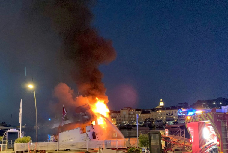 Photo prise et diffusée par les pompiers du SDIS 83 du Var, le 10 juillet 2025, montrant un superyacht en feu dans le port de Saint-Tropez ( SDIS83 / Handout )