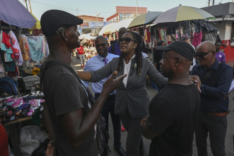 L'opposante Amanzia Walton-Desir (C), candidate outsider à la présidentielle au Guyana, s'adresse à des habitants sur marché de Georgetown, le 25 août 2025 ( AFP / Joaquin Sarmiento )