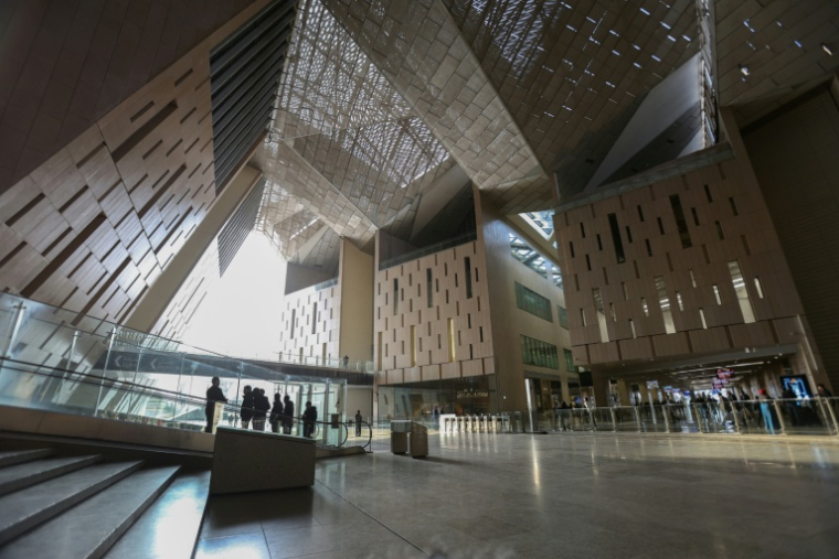 Des visiteurs marchent dans l'entrée du Grand musée égyptien (GEM) du Caire le 25 février 2025, avant son ouverture officielle ( AFP / Hasan MROUE )