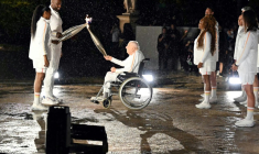 Charles Coste remettait la flamme olympique aux derniers porteurs Teddy Riner et Marie-José Pérec, lors de la cérémonie d'ouverture des Jeux de Paris 2024 le 26 juillet 2024, au Jardin des Tuileries ( AFP / MOHD RASFAN )
