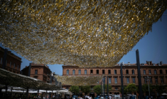 Des voiles étendus sur la place du Capitole à Toulouse pour fournir un peu d'ombre, le 19 juin 2026 ( AFP / Lionel BONAVENTURE )