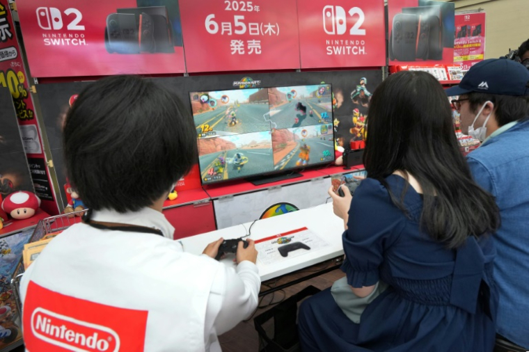 Des clients essaient la Nintendo Switch 2 dans une boutique d'électronique, le 5 juin 2025 à Tokyo ( AFP / Kazuhiro NOGI )