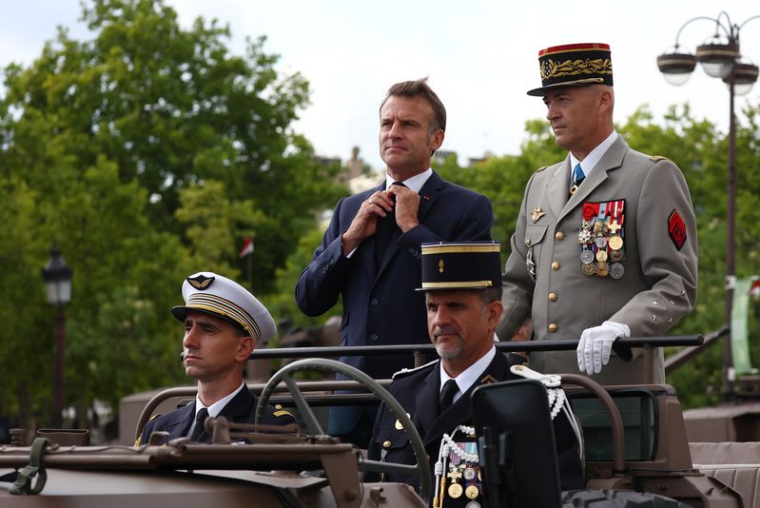 Le président français Emmanuel Macron aux côtés du Chef d'État-Major des Armées (CEMA) Thierry Burkhard lors du défilé militaire annuel de la fête nationale à Paris