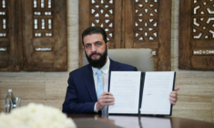 Le président syrien Ahmad al-Chareh montre un accord de cessez-le-feu signé à distance avec le chef des forces kurdes, le 18 janvier 2026 au palais présidentiel de Damas. ( AFP / Rami al SAYED )