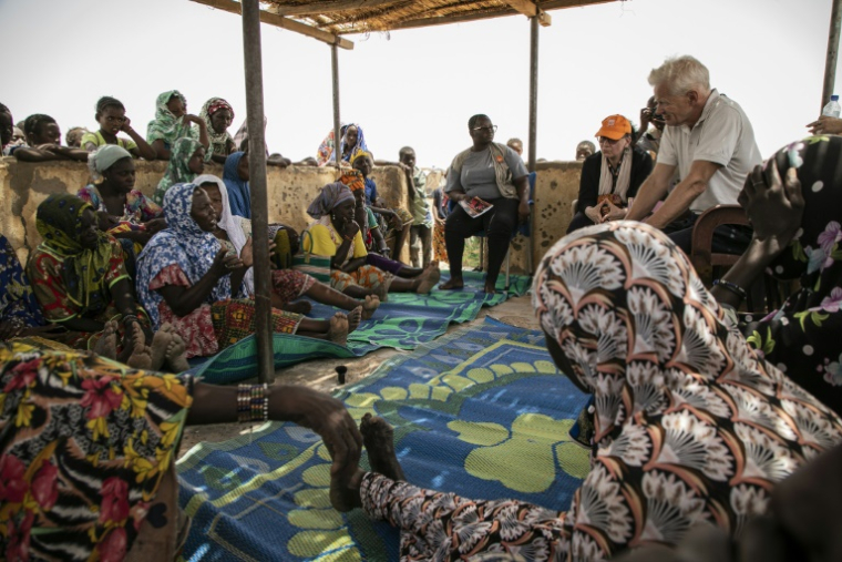 Jan Egeland (d), directeur du Conseil norvégien pour les réfugiés (NRC), rencontre des femmes déplacées au camp de Torodi à Dori, le 30 mai 2024 au Burkina Faso ( AFP / FANNY NOARO-KABRÉ )