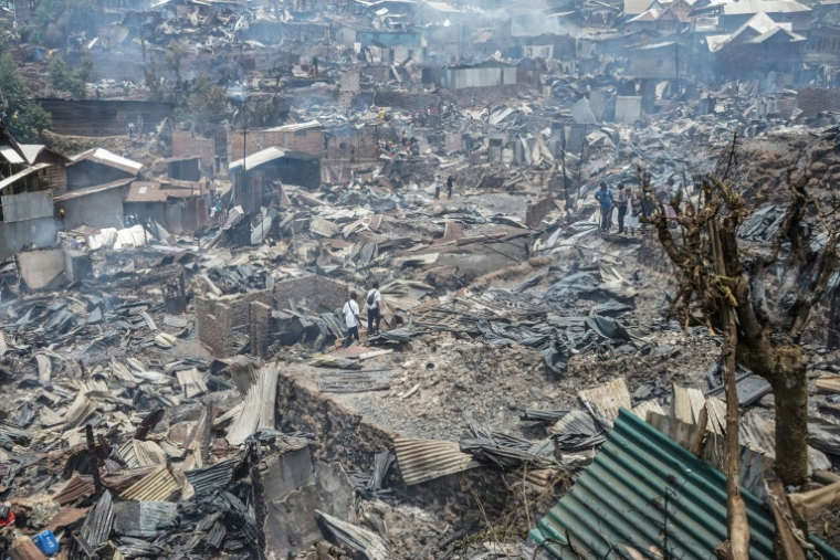 Des habitants au milieu des décombres après un incendie qui a ravagé une école à Bukavu, le 10 septembre 2026 en RDC ( AFP / Joseph Amani Alimasi )