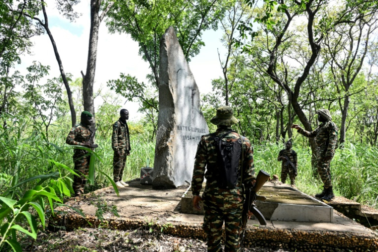 Des gardes forestiers rendent hommage à Raphaël Matta, tué par des braconniers en 1959, devant sa tombe dans le parc national de la Comoé, le 10 octobre 2025 dans le nord-est de la Côte d'Ivoire ( AFP / Issouf SANOGO )