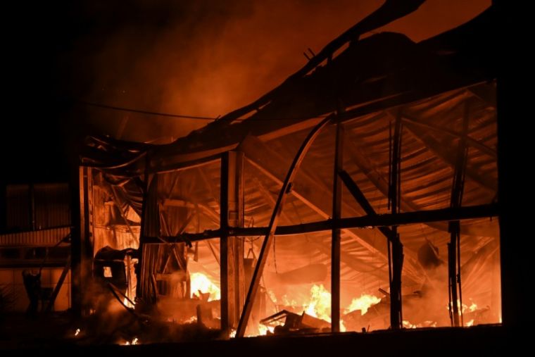 Des pompiers luttent contre un incendie sur le site d'une attaque de drone russe à Kharkiv, le 23 septembre 2025 en Ukraine ( AFP / SERGEY BOBOK )