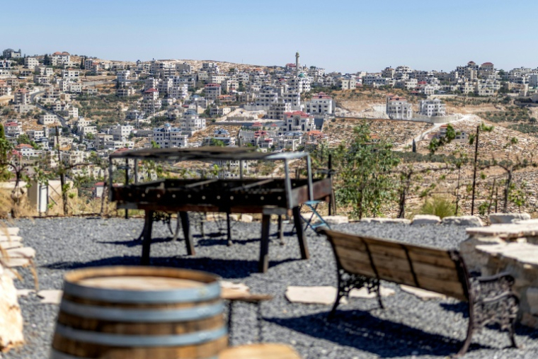 Le village palestinien de Mihkmas evu depuis la terrasse d'une exploitation viticole dans la colonie israélienne de Shaar Binyamin,  au sud-est de Ramallah, le 9 septembre 2026 en Cisjordanie occupée ( AFP / Ilia YEFIMOVICH )