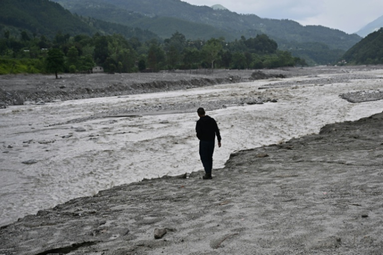 Un habitant au bord d'une rivière en crue à Devighat, dans le district de Nuwakot, le 7 septembre 2026 au Népal ( AFP / Pedro PARDO )