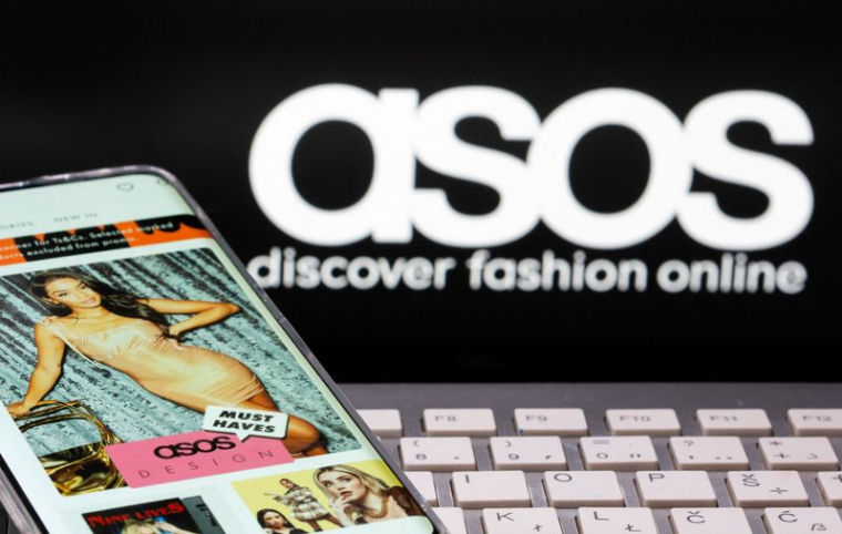 Un smartphone avec une application ASOS et un clavier sont visibles devant un logo ASOS affiché dans cette image d'illustration