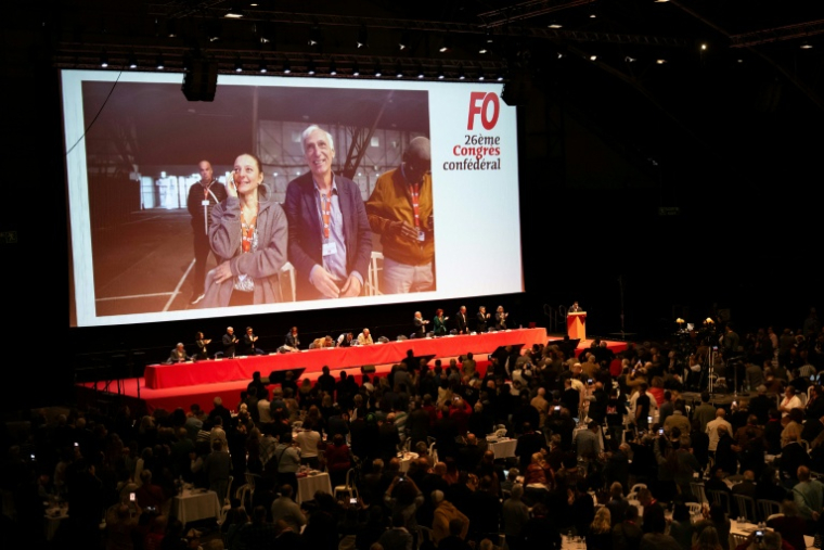 Cécile Kohler et Jacques Paris apparaissent sur un écran géant lors du 26e congrès national du syndicat français Force Ouvrière (FO), le 20 avril 2026 à Dijon, en Côte d'Or ( AFP / ARNAUD FINISTRE )