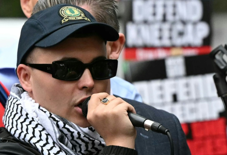 Mo Chara, membre du groupe de rap irlandais Kneecap, s'adresse à ses supporters devant le tribunal de première instance de Westminster à Londres, le 20 août 2025 ( AFP / JUSTIN TALLIS )