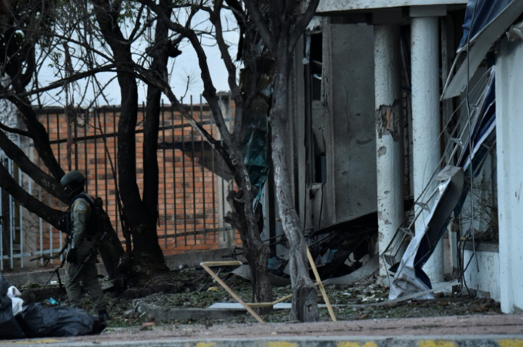 Un policier se tient près d'un bâtiment endommagé après l'explosion d'un camion bourré d'explosif près d'un commissariat de police dans la ville colombienne de Cúcuta, près de la frontière avec le Venezuela, le 1er août 2026  ( AFP / Schneyder Mendoza )