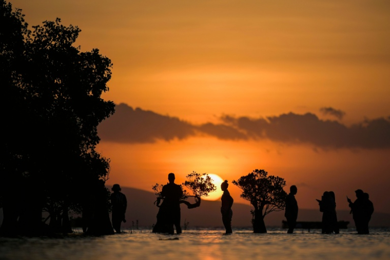 Des habitants dans l'eau sur la plage de Walakiri à Waingapu, sur l'île de Sumba, le 24 juin 2026 en Indonésie ( AFP / BAY ISMOYO )