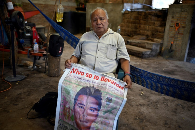 Estanislao Mendoza, le père de Miguel Ángel, l'un des 43 étudiants disparus dans l'État de Guerrero, tient une affiche avec la photo de son fils, le 14 mai 2025, à Apango, au Mexique ( AFP / Alfredo ESTRELLA )
