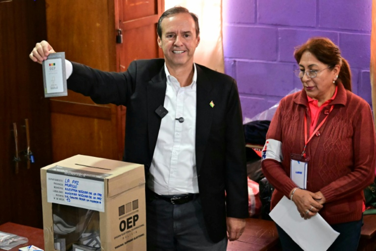 L'ancien président de la Bolivie et candidat à la présidence pour l'alliance Liberté et Démocratie (Libre), Jorge "Tuto" Quiroga, montre son bulletin de vote avant de l'insérer dans l'urne lors du second tour de l'élection présidentielle, à La Paz, en Bolivie, le 19 octobre 2025. ( AFP / MARTIN BERNETTI )