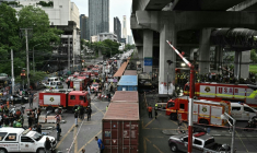 Des pompiers et secouristes sur le site d'une collision entre un train de marchandises et un bus à Bangkok, le 16 mai 2026 en Thaïlande ( AFP / Lillian SUWANRUMPHA )