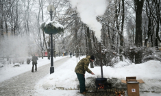 Un bénévole ukrainien cuisine un pain traditionnel d'Asie centrale dans un parc de Kiev, le 15 janvier 2026  ( AFP / Sergei GAPON )