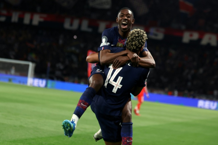 Ousmane Dembélé, auteur d'un doublé, dans les bras de Désiré Doué lors de la victoire 5-4 contre le Bayern Munich lors de la demi-finale aller de Ligue des champions, le 28 avril 2026 au Parc des Princes ( AFP / ALAIN JOCARD )