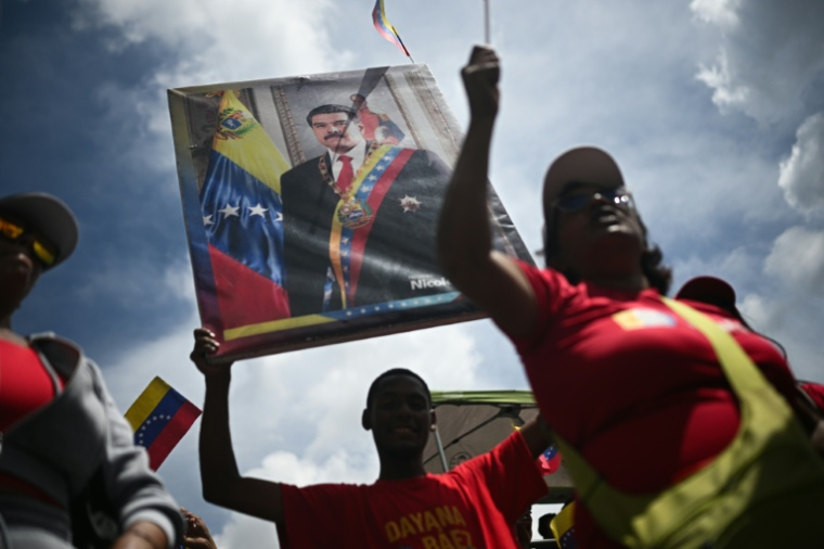 Un homme tient un portrait du président vénézuélien Nicolas Maduro, le 23 septembre 2025 à Caracas ( AFP / Federico PARRA )
