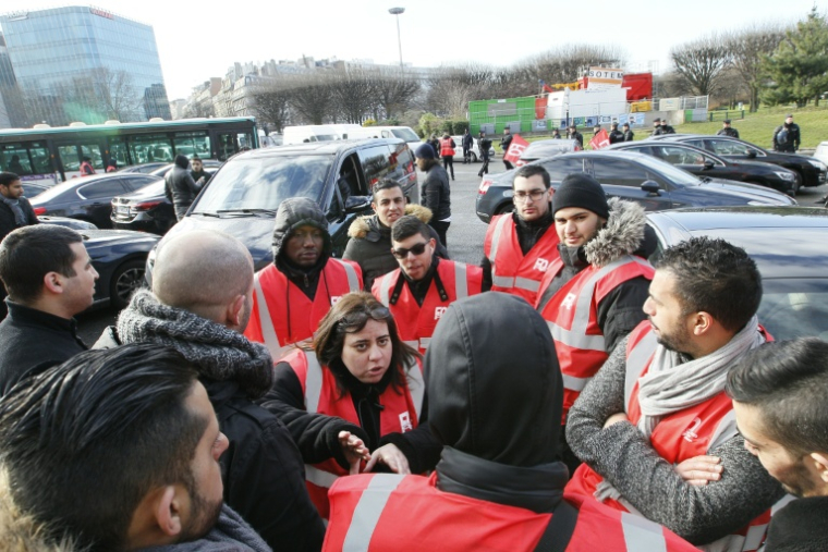 Des délégués syndicaux de Force Ouvrière (FO) parlent avec des chauffeurs de VTC lors d'une action Porte Maillot à Paris, le 11 février 2016 ( AFP / MATTHIEU ALEXANDRE )