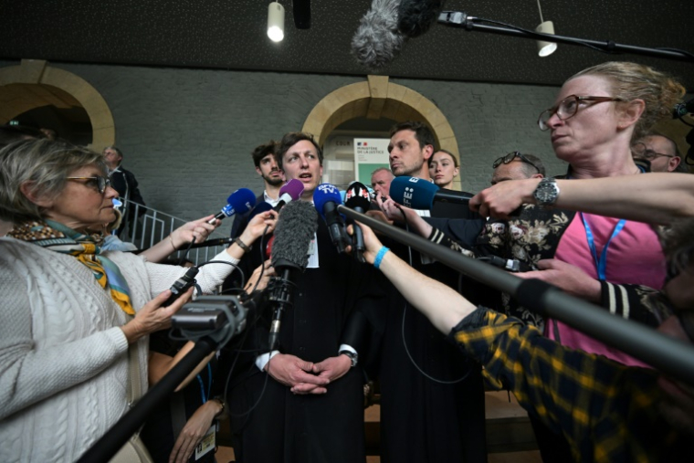 Les avocats de Joël Le Scouarnec, Maxiqume Tessier (c,g) et Thibaut Kurzawa (c,d) répondent aux questions des journalistes après la condamnation de l'ex-chirurgien pédocriminel à 20 ans de réclusion, le 28 mai 2025 à Vannes, dans le Morbihan ( AFP / Damien Meyer )